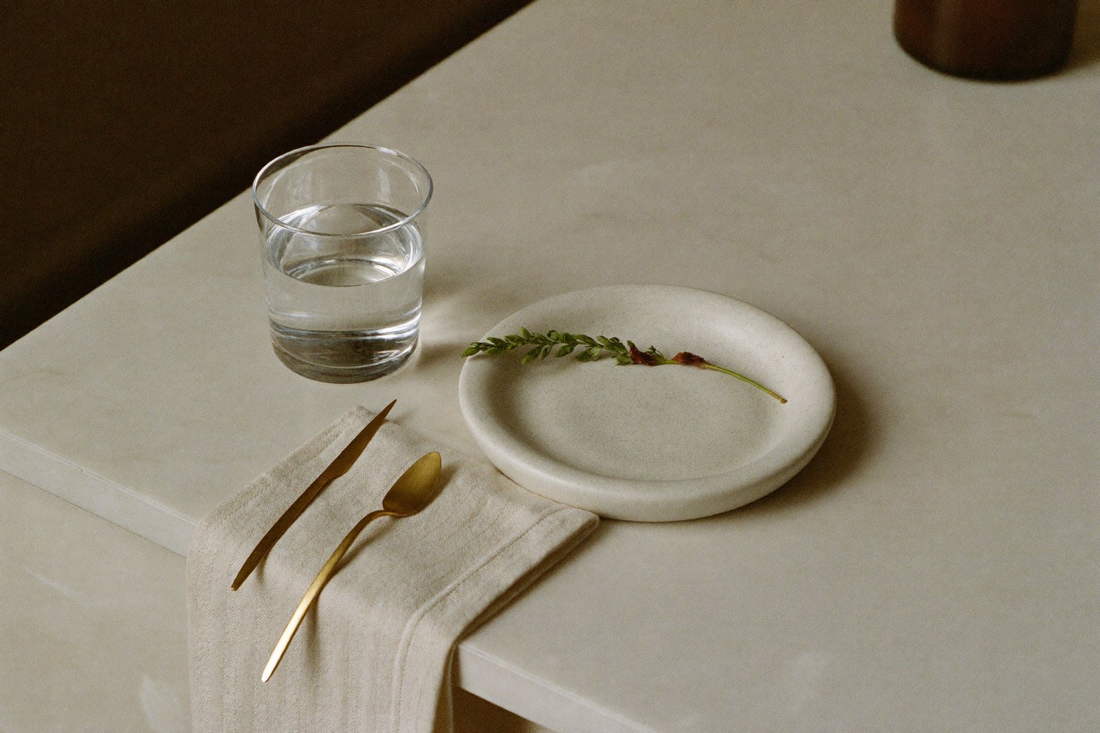 A calm still-life — a glass of water and considered objects in soft morning light
